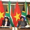 Vietnamese Deputy Foreign Minister Nguyen Minh Hang (L) and South African Deputy Minister of International Relations and Cooperation Anna Thandi Moraka sign the minutes of the 6th meeting of the Vietnam - South Africa Intergovernmental Partnership Forum in Pretoria on November 27. (Photo: VNA)