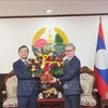 Ambassador Nguyen Minh Tam (left) present flowers to congratulate Lao Foreign Minister Thongsavanh Phomvihane on the 49th anniversary of Laos' National Day. (Photo: VNA) 