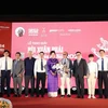 Participating delegates, representatives of the organisers of the Bui Xuan Phai - For the Love of Hanoi Awards congratulate Architect Hoang Dao Kinh on the stage. (Photo: VietnamPlus)