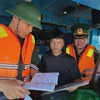 Border guards check documents and procedures before fishing boats leave the port. (Photo:VNA)