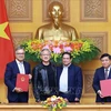 Prime Minister Phạm Minh Chính (second from right) and NVIDIA founder and chief executive officer Jensen Huang (second from left) witness the signing of a cooperation agreement on artificial intelligence research between Vietnamese government and NVIDIA Group. (Photo: VNA)