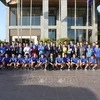 Representatives of the Vietnamese Embassy in Laos and the Vietnamese national men's football team pose for a group photo. (Photo: VNA)