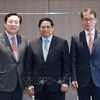 El primer ministro de Vietnam, Pham Minh Chinh (centro); el presidente de la Federación surcoreana de empresas medianas y pequeñas (KBIZ), Kim Ki-moon (izquierda), y el presidente y director ejecutivo del Banco Industrial de Corea del Sur (IBK), Kim Sung-tae. (Foto: VNA)