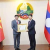 El embajador de Vietnam en Laos, Nguyen Ba Hung (izquierda), recibe la Orden de la Libertad (Issara) de Tercera Clase de Laos. (Foto: VNA)