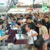 Viajeros completan los procedimientos para embarcar en los aviones en la temporada alta del verano de 2024. (Foto: VietnamPlus)