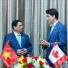 El primer ministro vietnamita, Pham Minh Chinh (izquierda), conversa con su homólogo canadiense, Justin Trudeau. (Foto: VNA)