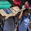 Des étudiants utilisent un carton pour se protéger du soleil lors d'une chaude journée à Manille le 2 avril 2024. (Photo : philstar.com)