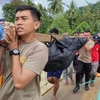 Des secouristes transportent le corps d'une personne décédée dans le glissement de terrain du village de Tulabolo, en Indonésie, le 9 juillet. (Photo : AFP)