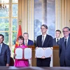 La Dr Nguyen Thi Phuong Thao, présidente de Vietjet, Dinh Viet Phuong, directeur général de Vietjet (premier, gauche), Olivier Andries, Président-directeur général de Safran (2 à droite) et Gaël Méheust, président-directeur général de CFM International (droite) lors de la cérémonie signature en présence du digigeant To Lam et du président français Emmanuel Macron. Photo