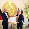 L'ambassadeur du Vietnam en Allemagne Vu Quang Minh a remis l'Ordre de l'amitié au Dr Guido Hildner, ancien ambassadeur d'Allemagne au Vietnam (droite), à Berlin le 9 octobre. Photo : VNA