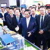 越南总理范明政参观科技应用产品展位。图自越通社