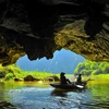 The caves are surrounded by the Ngo Dong River and rice fields stretching along the foot of the mountains, immersing visitors in the surrounding nature. (Photo: VietnamPlus)