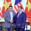 Prime Minister Pham Minh Chinh (R) and Speaker of the Malaysian House of Representatives Tan Sri Dato' Johari Bin Abdul in Hanoi on October 25. (Photo: VNA)