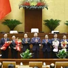 Party General Secretary To Lam (C), Prime Minister Pham Minh Chinh (4th from right) and NA Chairman Tran Thanh Man (4th from left) congratulate the newly-appointed ministers and justices of the Supreme People's Court. (Photo: VNA)