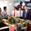 越南安江省和柬埔寨茶胶和甘丹两省领导参观 展位。图自越通社