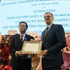 法国驻越南特命全权大使奥利维尔·布罗谢向阮武国辉教授授予国家功绩骑士勋章。图自越通社