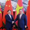 越南政府总理范明政（左）与中国国务院总理李强握手。图自越通社