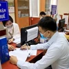 A tax official assists a man in filling out his tax returns in the capital city of Hanoi. (Photo: VNA) 