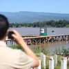 A visitor takes photos of the construction of the fifth Thai-Lao Friendship Bridge, between Bung Kan and Bolikhamxay, on October 28, 2022. The two countries have plans for another bridge, between Udon Ratchathani and Saravan. (Photo: bangkokpost.com)