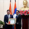 Secretary of the Party Committee and Governor of Sekong province Leklai Sivilay (Right) presents a third-class Issara (Freedom) Order of Laos to Standing Vice Chairman of the Da Nang People's Council Tran Phuoc Son. (Photo: VNA)