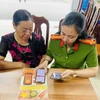 A police officer instruct a resident in Tien Yen district, Quang Ninh province to use app VNeID. (Photo: congan.quangninh.gov.vn)