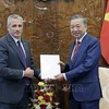Ambassador of the Republic of Belarus to Vietnam Uladzimir Baravikou (left) hands over to President To Lam a congratulation letter from the President of Belarus. (Photo: VNA)