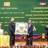 President To Lam (left) gives a gift to the Royal University of Phnom Penh. (Photo: VNA)