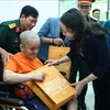 Vice President Vo Thi Anh Xuan gives a gift to an AO victims at the centre for caring, nurturing and treating victims of AO/dioxin in Ba Vi district, Hanoi. (Photo: VNA)