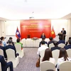 Prime Minister Pham Minh Chinh (standing) speaks at the meeting with staff of the Vietnamese Embassy and Vietnamese representative agencies in Laos on October 8. (Photo: VNA)