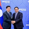 Prime Minister Pham Minh Chinh (R) and Lao Party General Secretary and State President Thongloun Sisoulith in Kazan, Russia, on October 23 when attending the expanded BRICS Summit. (Photo: VNA)