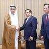 Prime Minister Pham Minh Chinh (C) receives Qatari Minister of Labour Ali bin Saeed bin Samikh Al Marri in Doha on October 31. (Photo: VNA)