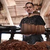 An artisan shapes the outside of a wood log. (Photo: VNA) 