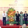 Party General Secretary To Lam (L) presents flowers to congratulate the Party Committee, People's Committee and Vietnam Fatherland Front Committee of Quan Thanh ward in Ba Dinh district of Hanoi. (Photo: VNA)