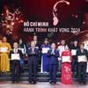 Party General Secretary To Lam (third from left, front row) and Politburo member, Secretary of the Party Central Committee and Chairman of the Party Central Committee's Commission for Information and Education Nguyen Trong Nghia (fourth from right, front row) present Certificates and Emblems to honour 25 typically outstanding models nationwide in studying and following President Ho Chi Minh's thought, morality and style. (Photo: VNA)