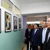 The delegation visits an area displaying photos on President Ho Chi Minh in the school (Photo: sggp.org.vn)