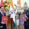 Leaders of the foreign ministries of Vietnam and India exchange an agreement between their governments allowing family members of diplomatic and consular staff to work for income. (Photo: VNA)