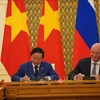 Deputy Prime Minister Tran Hong Ha (L) and his Russian counterpart Dmitry Chernyshenko sign the meeting's minute (Photo: VNA)