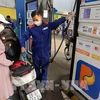 A customer buys petrol at a petrol station in Hanoi. The retail prices of E5RON92 bio-fuel and all petrol products decrease from 3pm on July 11 (Photo: VNA)