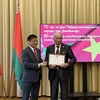El embajador Dang Van Ngu entrega certificado a personas que aportan a la amistad entre los dos países. (Fuente: VNA)