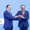 El primer ministro de Malasia, Anwar bin Ibrahim, recibe el mazo de la presidencia de la ASEAN de manos de su homólogo laosiano, Sonexay Siphandone. (Fuente: VNA)