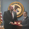 越南公安部副部长阮文龙中将向美国监狱管理局副局长夏恩·塞勒姆赠送纪念品。图自越通社