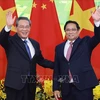 Prime Minister Pham Minh Chinh (right) and Chinese Premier Li Qiang pose for a photo before their talks in Hanoi. (Photo: VNA)