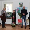 旅居比利时越南女画家金团和代表们在“爱之土地”的画展开幕式上。图自越通社