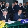 国家主席苏林与政府总理范明政在吊唁簿上题词。图自越通社