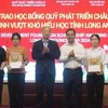 Nguyen Van Duoc, Secretary of the provincial Party Committee and Chairman of the Long An People's Council; Kim Joon Il, Chairman of COBI Group and ADF; and students at the ceremony. (Photo: VNA)