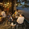 Customers of a riverside 'moo krata' (barbecued pork buffet) in Nonthaburi's Soi Phibulsongkhram 21 do not mind having their feet soaked during high tide in the Chao Phraya River on Sunday. Some describe it as a unique dining experience. (Photo:bangkokpost.com) 