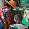 A woman looks for lottery tickets with numbers she favours at a stall in Phra Nakhon district, Bangkok. (Photo: bangkokpost.com) 