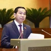 Chairman of the NA’s Finance-Budget Committee Le Quang Manh briefs the NA on the adjustments that NA Standing Committee has made to the draft resolutions. (Photo: VNA)