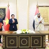 Prime Minister Pham Minh Chinh (second from left) and UAE Vice President and Prime Minister Sheikh Mohammed bin Rashid Al Maktoum (second from right) witness the signing of Comprehensive Economic Partnership Agreement between Vietnam and the United Arab Emirates. (Photo: VNA)