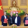 PM Pham Minh Chinh (second from right) and NVIDIA President and CEO Jensen Huang (third from right) witness the signing ceremony of the agreement between the Vietnamese Government and the US giant tech. (Photo: VNA)